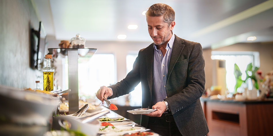 Uomo d'affari in una stazione di cibo self-service in un hotel