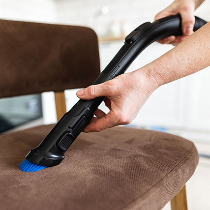 close up of a vacuum on an upholstered wooden chair