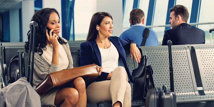 Mujeres de negocios en el teléfono esperando el avión