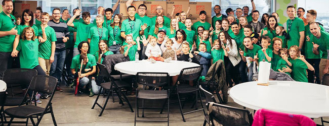 Grande grupo de pessoas reunidas para uma foto em uma cafeteria