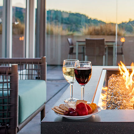 chair next to a fire with wine and food