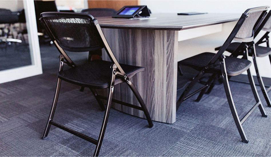 Trois chaises pliantes installées autour d’un bureau