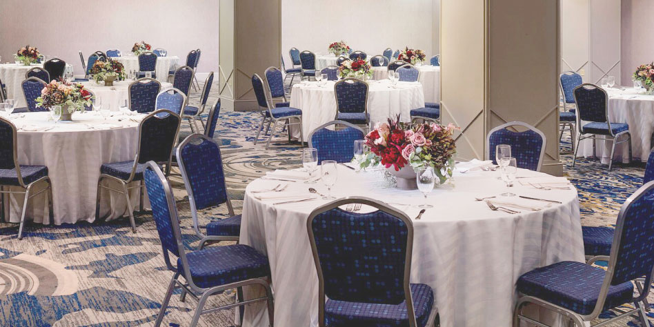 Installation de chaises et de tables rondes dans une grande salle de banquet