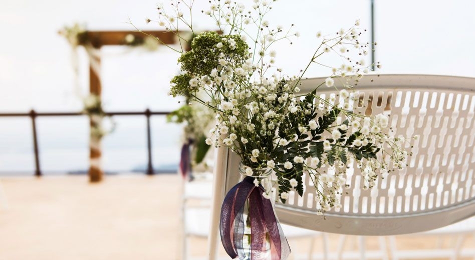 Une chaise pliante MityLite avec des fleurs violettes vibrantes, ajoutant une touche d'élégance et de couleur au meuble