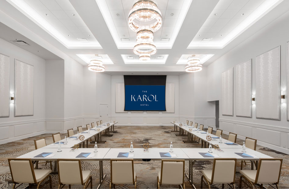 Longue salle avec tables et chaises installées en forme de U pour une présentation