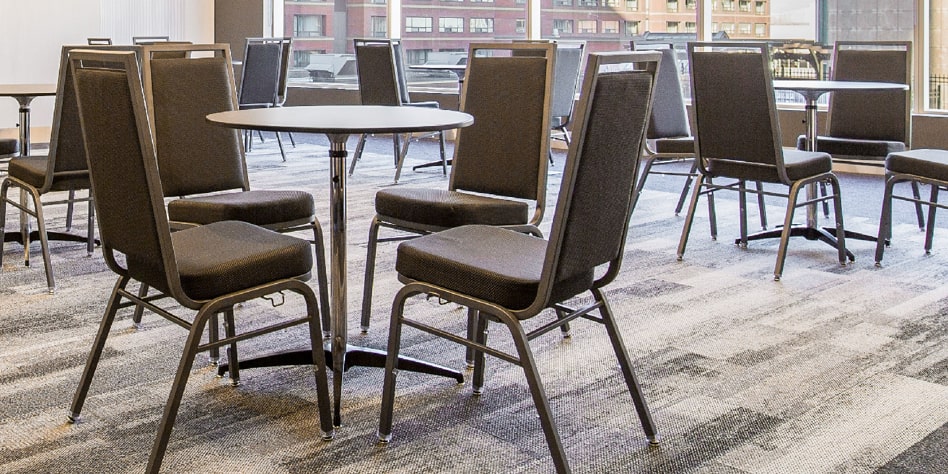 Banquet chairs surrounding an adjustable ABS cocktail table by MityLite