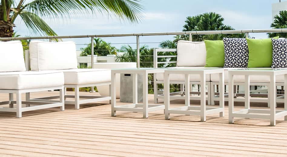 Muebles de exterior de metal blanco y moderno con cojines a juego y almohadas de colores vivos.