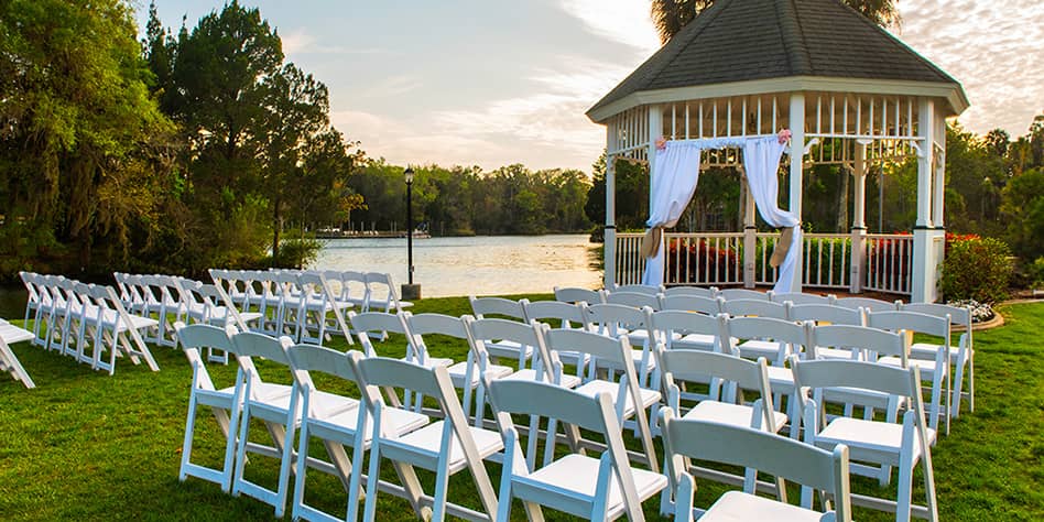 White plastic folding chairs lined up surrounding an outdoor gazebo