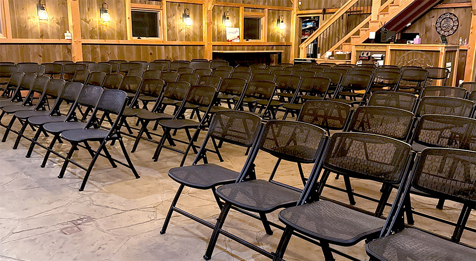 Chaises pliantes MeshOne dans un espace événementiel de type grange