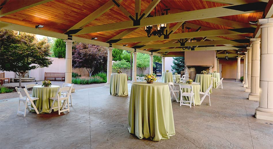 white folding chairs at short cocktail tables in an outdoor reception space