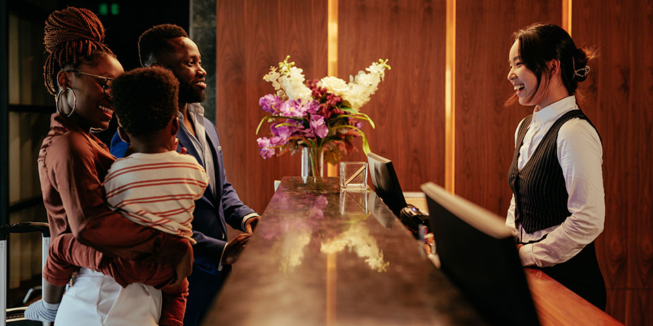 Hotel worker greeting a couple and their small child