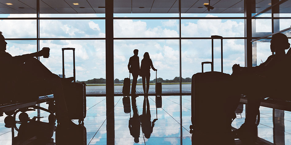 Personas en un aeropuerto mirando por la ventana.