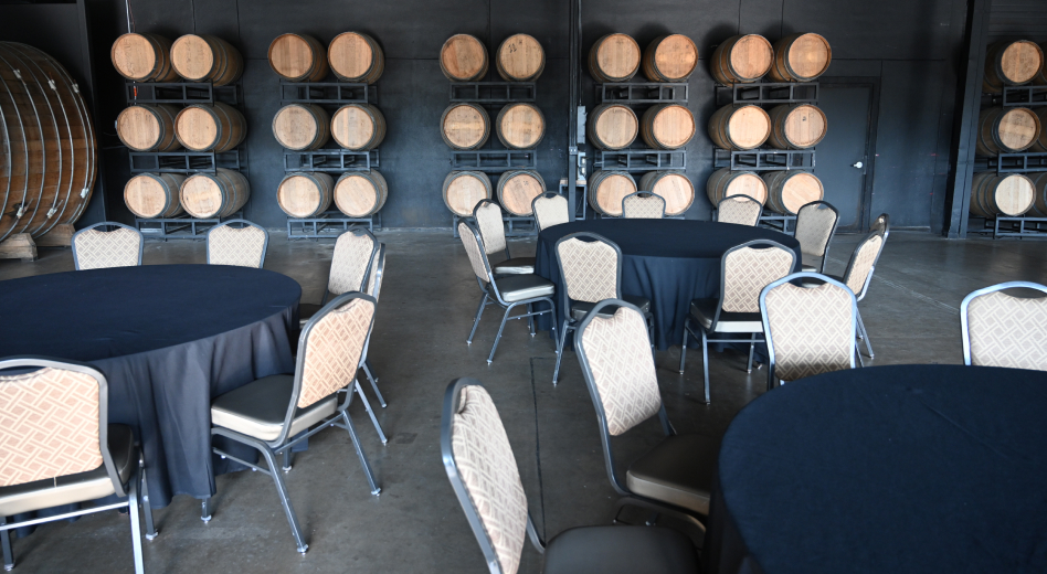 Upholstered banquet chairs with metal frames at tables in a restaurant with industrial decor