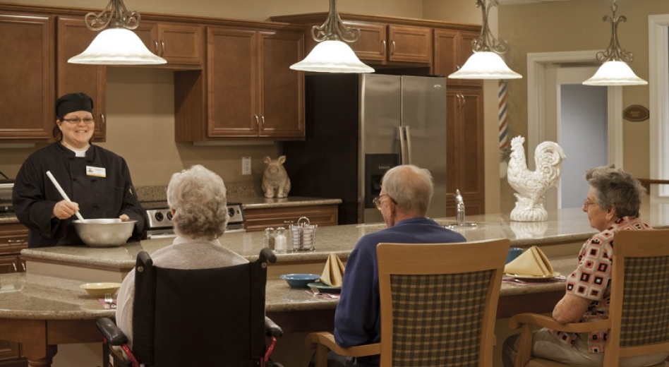 A group of elderly people sitting at a cooking demonstration