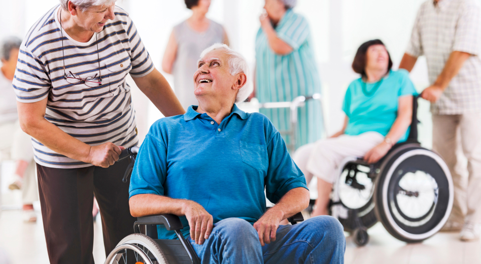 Man in wheelchair smiling at his wife