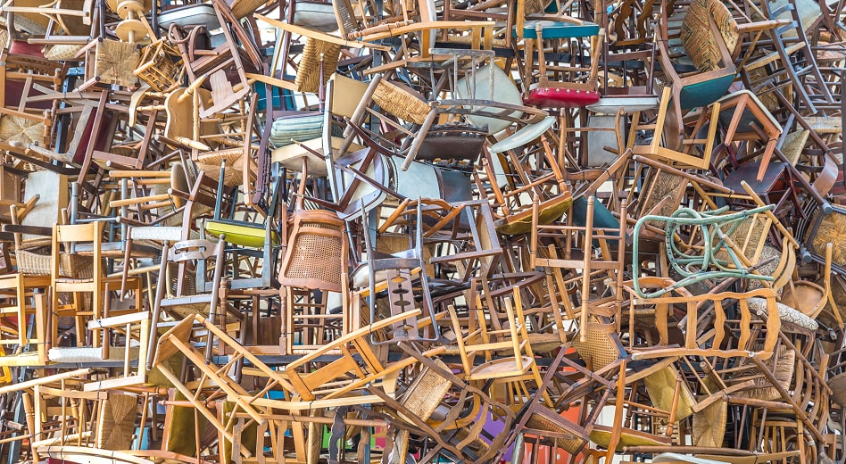 Several dozen inexpensive restaurant chairs in a pile