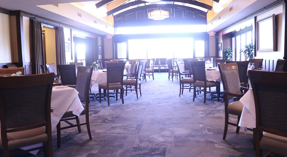 Elegant country club dining space with armchairs and side chairs.