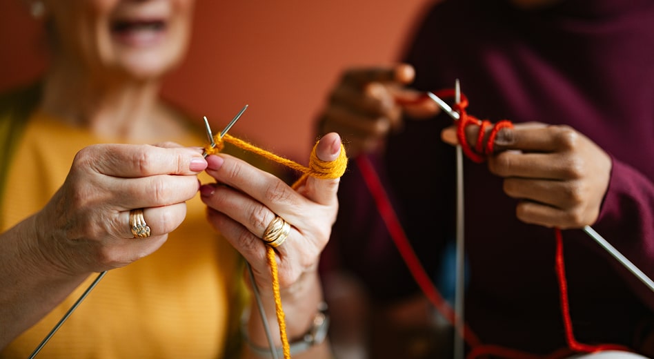 Two senior citizens knitting.