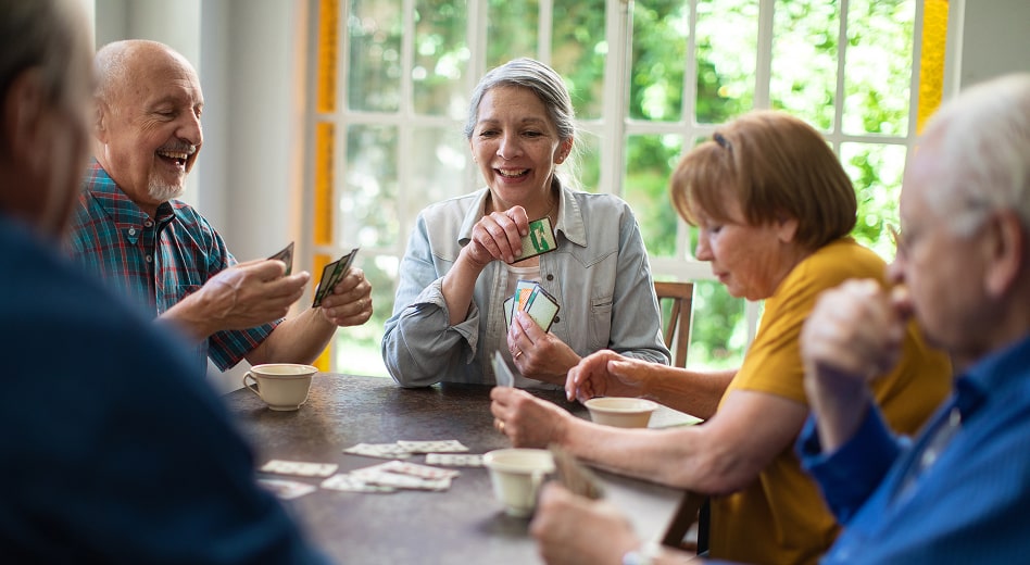 A group of senior citizens playing poker at a table.