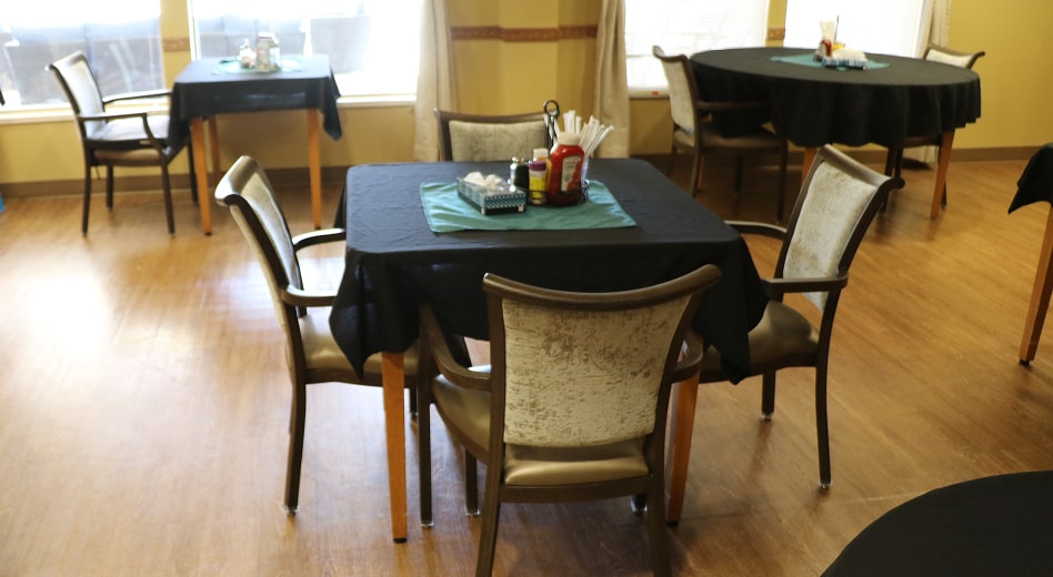 Stacking dining chairs at a table.