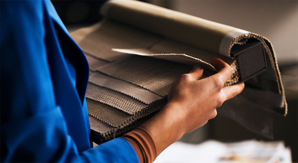 Close up of a person holding a fabric swatch booklet