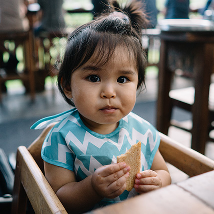 Niño sentado en una silla alta en un restaurante.