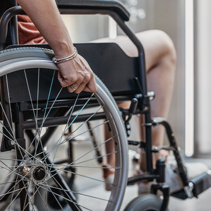 Close up of a hand upon a wheelchair rim