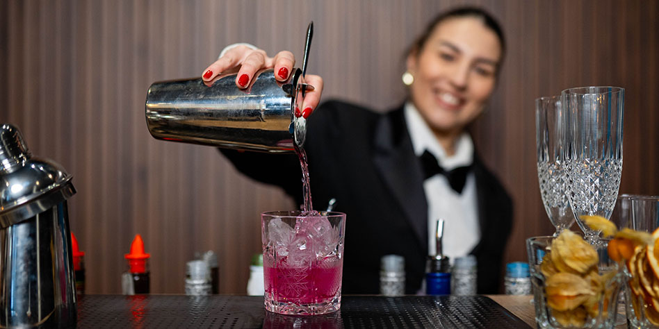 Bartender pouring a drink behind a mobile bar