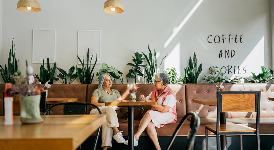 Two people chatting in a coffee shop space