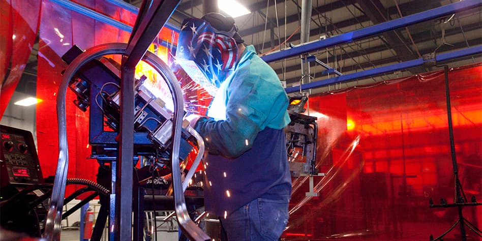 MITY employee welding in the manufacturing facility